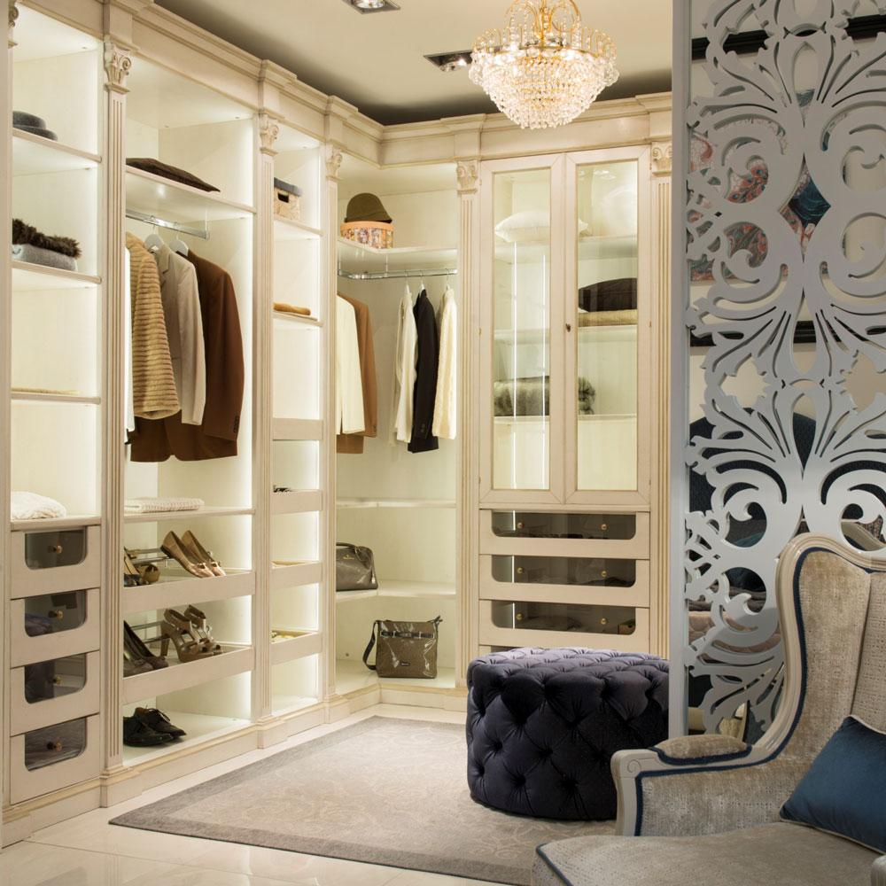 Custom Italian furniture closet system with cream cabinetry, crystal chandelier, and decorative screen.